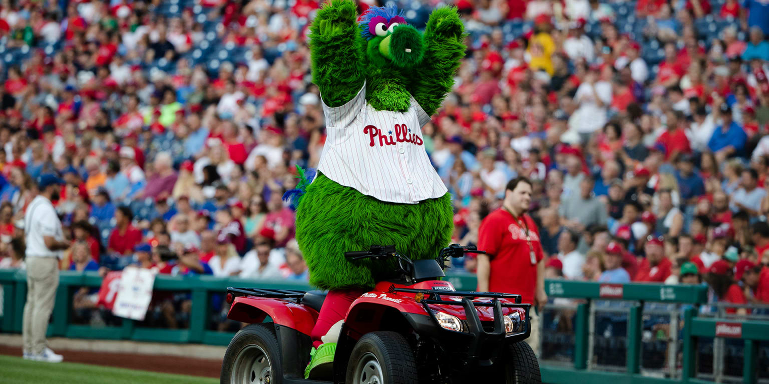 the phillie phanatic standing on his red ATV with his arms up